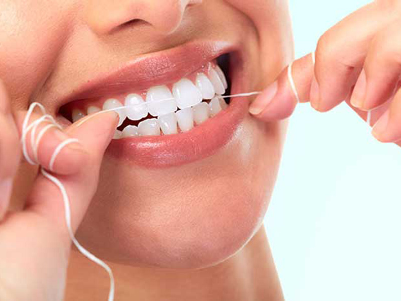 A women Flossing her teeth