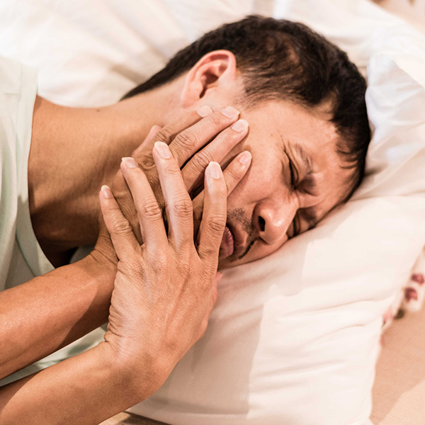 A man holding cheek in teeth pain