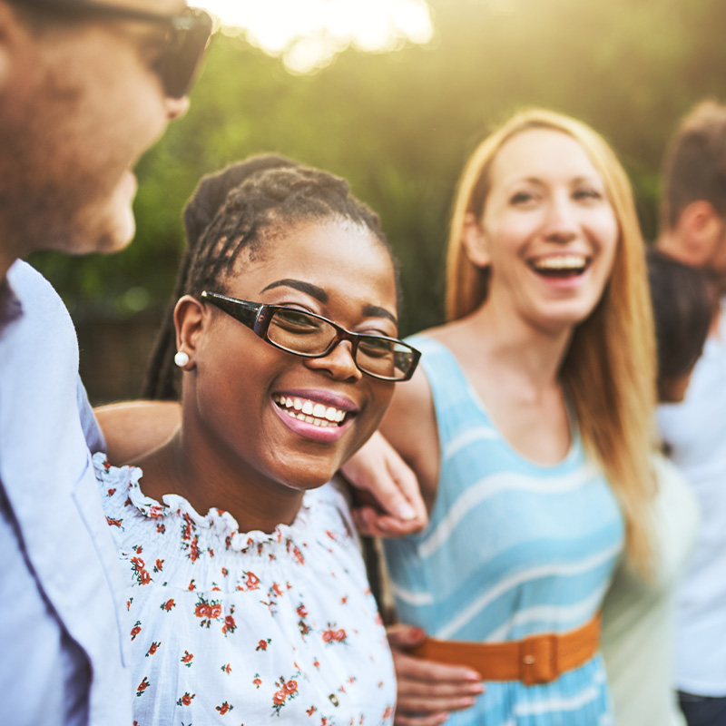 Shot of a group of young friends standing arms around outside during the day