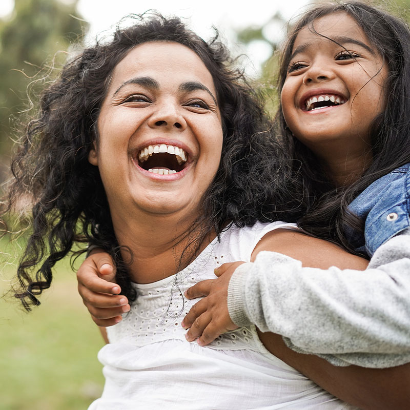 Happy mother and daughter smiling and having fun outdoors