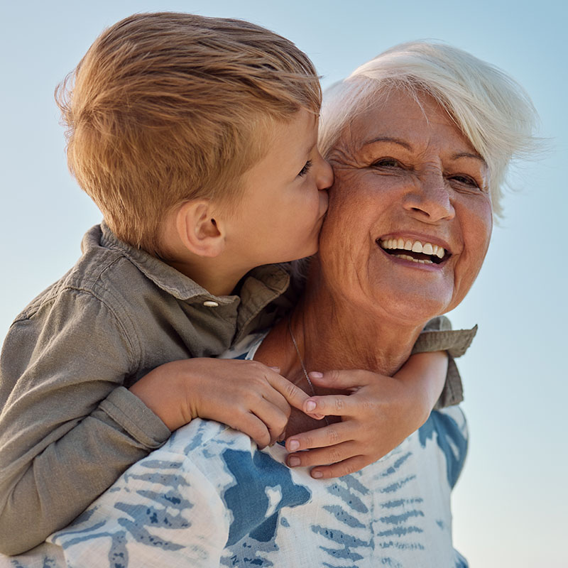 Kiss, child and grandmother in a park with love