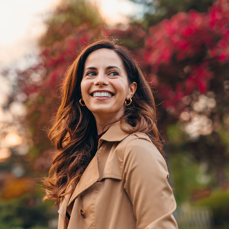 A person outdoors with a bright smile, highlighting porcelain inlay dental care in Edmonton, AB